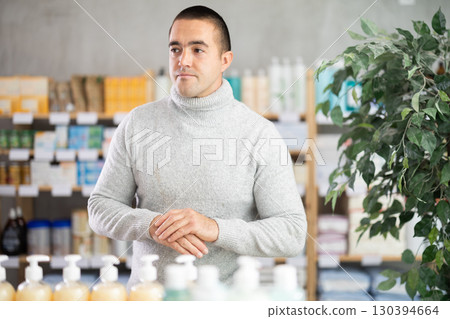 Man in drugstore looking for something 130394664