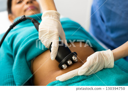 Woman cosmetologist making ultrasound lifting procedure Woman cosmetologist making ultrasound lifting procedure 130394750