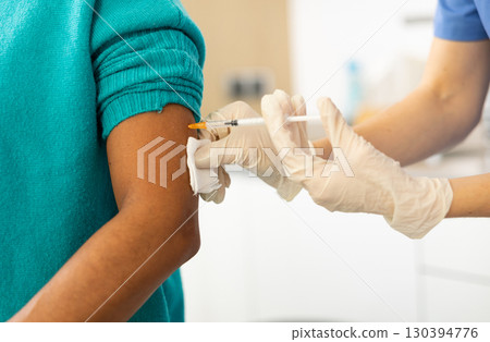 Female nurse vaccinating patient Female nurse vaccinating patient 130394776