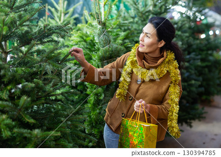Portrait of asian woman buying Christmas tree at Christmas market Portrait of asian woman buying Christmas tree at Christmas market 130394785