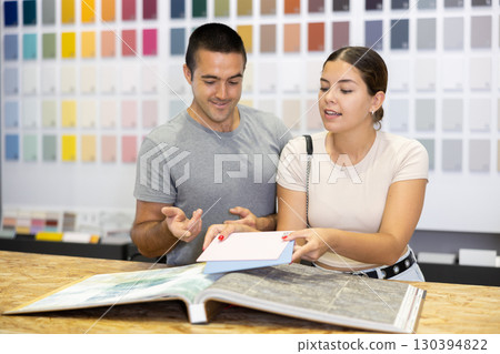 Married couple together choose color of ceramic tiles from catalog in hardware store Married couple together choose color of ceramic tiles from catalog in hardware store 130394822