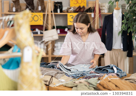 Teenager chooses jeans on sale 130394831