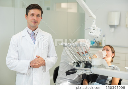 Man doctor dentist is standing in dental office, clinic Man doctor dentist is standing in dental office, clinic 130395006