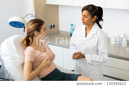 Plastic surgeon and woman discussing breast augmentation 130395023