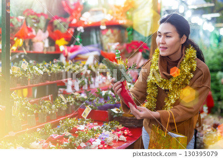 Woman choosing christmas decoration at street fair 130395079