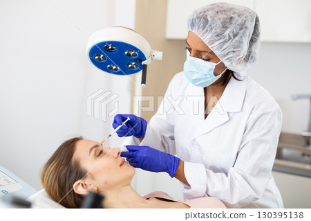 Woman receiving cosmetic facial injection at clinic Woman receiving cosmetic facial injection at clinic 130395138