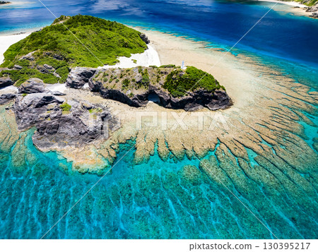 Drone footage of Kabi Island. Tourists are landing on the white sand beach. Parasols are set up, and boats and sabani boats are moored. Drone footage of Kabi Island. Tourists are landing on the white sand beach. Parasols are set up, and boats and sabani boats are moored. 130395217