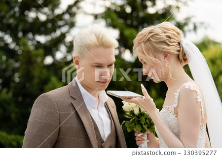 Bride and groom sharing a moment during wedding ceremony in a garden Bride and groom sharing a moment during wedding ceremony in a garden 130395277