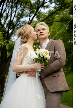 Romantic outdoor wedding photography at a lush green park in springtime 130395283
