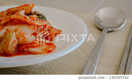 桌上的納帕捲心菜泡菜 — 韓國料理，用筷子和湯匙供應的美味佳餚 130395582