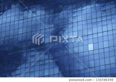 A view of a glass skyscraper reflecting the sky, showcasing the intricate grid pattern and the interplay of light and shadow. 130396399