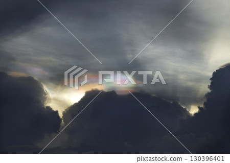 Beautiful Iridescent clouds over the dark sky. occur when sunlight diffracts off water droplets in the atmosphere. 130396401
