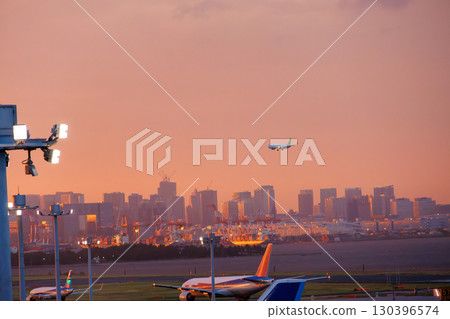 The deck of Haneda Airport at sunset. You can see passenger planes taking off and landing and the Tokyo cityscape at dusk. 2025 The deck of Haneda Airport at sunset. You can see passenger planes taking off and landing and the Tokyo cityscape at dusk. 2025 130396574