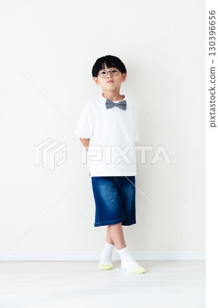 站在白牆前的小學男孩 130396656