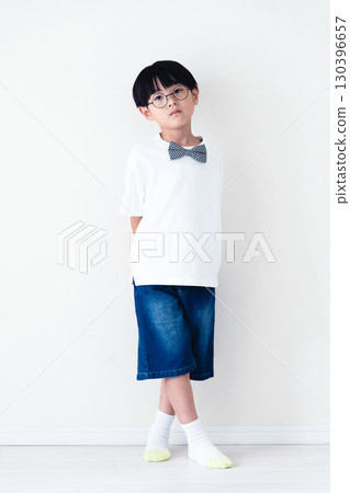 站在白牆前的小學男孩 130396657