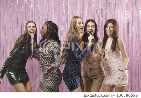 Happy beautiful smiling multiracial friends girls fun karaoke singing, women have hen party at club Happy beautiful smiling multiracial friends girls fun karaoke singing, women have hen party at club 130396659