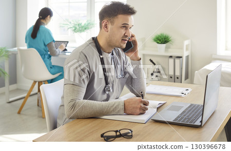 Male Doctor Working With Laptop In Hospital Office 130396678