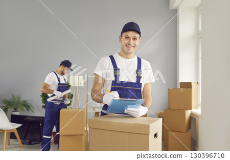 Young smiling mover man checking items list for moving, individual or company worker  130396710