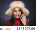 portrait of a beautiful smiling girl in a fur cap 130397366