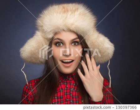 portrait of a beautiful smiling girl in a fur cap 130397366
