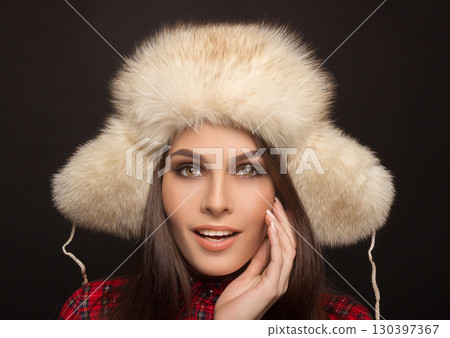 portrait of a beautiful smiling girl in a fur cap 130397367