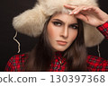 portrait of a beautiful girl in shirt and fur hat 130397368