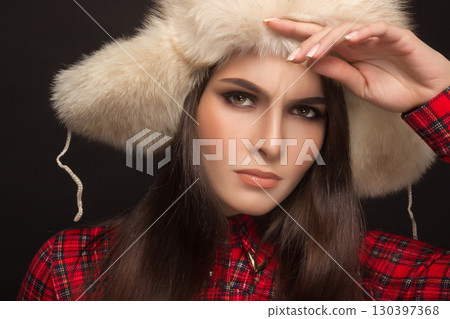 portrait of a beautiful girl in shirt and fur hat 130397368
