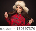 beautiful smiling girl in a shirt and a fur cap 130397370