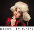 portrait of a beautiful girl in shirt and fur hat 130397371