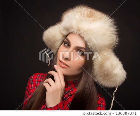 portrait of a beautiful girl in shirt and fur hat 130397371