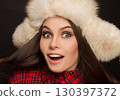 portrait of a beautiful happy girl in a fur hat and shirt 130397372