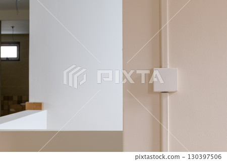 Calm minimalist interior detail of house renovation showing electrical conduit on beige wall. simple background for any construction project or home improvement idea Calm minimalist interior detail of house renovation showing electrical conduit on beige wall. simple background for any construction project or home improvement idea 130397506