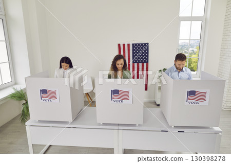 People stand in voting booths and think before making choice in America's elections. People stand in voting booths and think before making choice in America's elections. 130398278