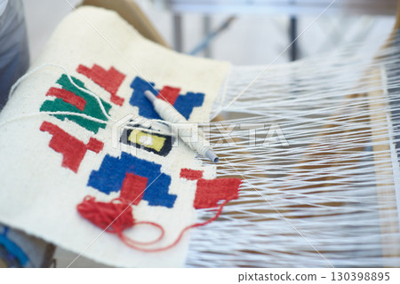 Traditional Wool Weaving on Loom with Shuttle and Yarn 130398895