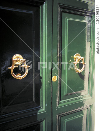 Old street in Rome. Knockers attached to the doors of private houses. 130399384