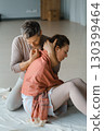 Couple engaging in a warm embrace during a morning meditation session in a bright, serene studio space 130399464