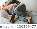 Couple cuddling on a cozy blanket in a serene indoor space during a lazy afternoon, enjoying each other's warmth and intimacy 130399477