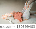 Wellness session in a serene studio focuses on relaxation techniques using a supportive wrap during a tranquil midday practice 130399483