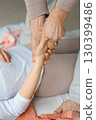 Hands engage in a gentle, therapeutic treatment session at a wellness center during a guided healing workshop focused on relaxation and connection 130399486
