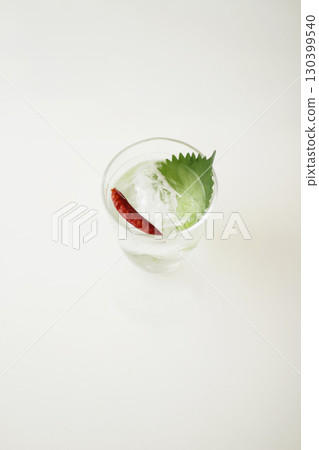 辣椒和紫蘇燒酒盛放在涼爽的魚缸般的玻璃杯中 130399540