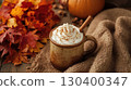 Autumn pumpkin spice latte in rustic ceramic mug with whipped cream and cinnamon stick on cozy brown knit blanket, surrounded by vibrant fall leaves. National Coffee Day concept. 130400347