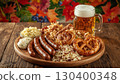A traditional Oktoberfest meal with Close-up of Bavarian sausages, salted pretzels, cheese, sauerkraut and a refreshing cold foamy light beer on a rustic table. Autumn leaves in the background. 130400348