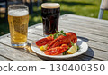 A refreshing pairing of lobster with lemon wedges served alongside two glasses of beer, one pale ale and one stout, captured in bright sunlight on a wooden table. Perfect for a Pizza and Beer Day. 130400350