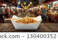 A steaming bowl of shrimp noodles in a take-out box, garnished, placed on a table, with the lively night market scene blurred in the background for a cozy street food vibe. National Noodle Day concept 130400352
