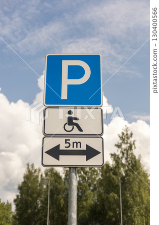 A sign displays parking regulations for accessible spaces with a wheelchair symbol, located under a clear sky, highlighting necessary parking distance A sign displays parking regulations for accessible spaces with a wheelchair symbol, located under a clear sky, highlighting necessary parking distance 130400566