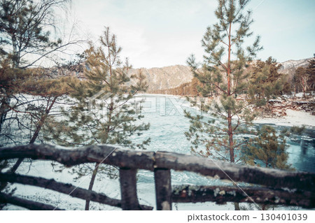 winter mountain river with turquoise water flowing through snowy forest framed by pine trees and wooden fence, concept of nature travel, scenic landscape, ecology and outdoor tourism winter mountain river with turquoise water flowing through snowy forest framed by pine trees and wooden fence, concept of nature travel, scenic landscape, ecology and outdoor tourism 130401039