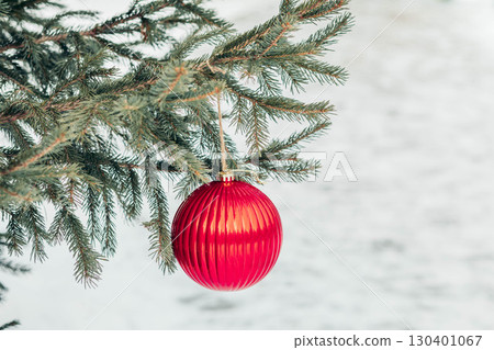 red Christmas bauble hanging on spruce branch outdoors with snow background, holiday decoration detail and concept of winter celebration and festive mood red Christmas bauble hanging on spruce branch outdoors with snow background, holiday decoration detail and concept of winter celebration and festive mood 130401067