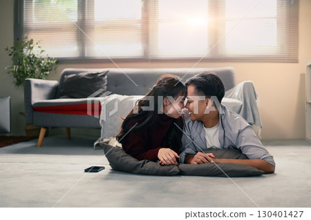 Cheerful couple relaxing at home, embracing love and connection with tender eye contact Cheerful couple relaxing at home, embracing love and connection with tender eye contact 130401427