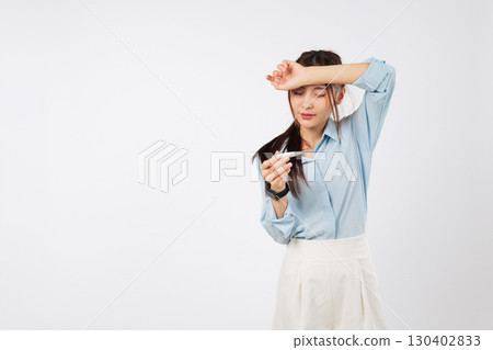 Asian sick woman, feverish with hand on forehead, checks temperature, feeling sick, reading thermometer to measure illness and seeking medical care for her health, isolated studio white background 130402833
