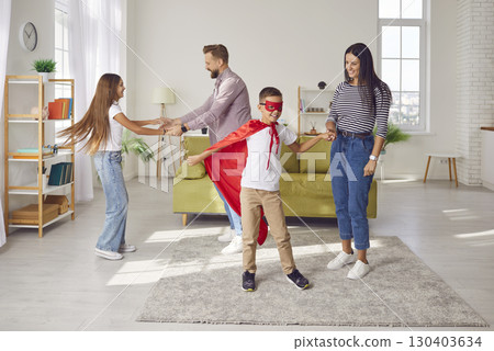 Happy parents and children dancing and having fun at family party in living room 130403634